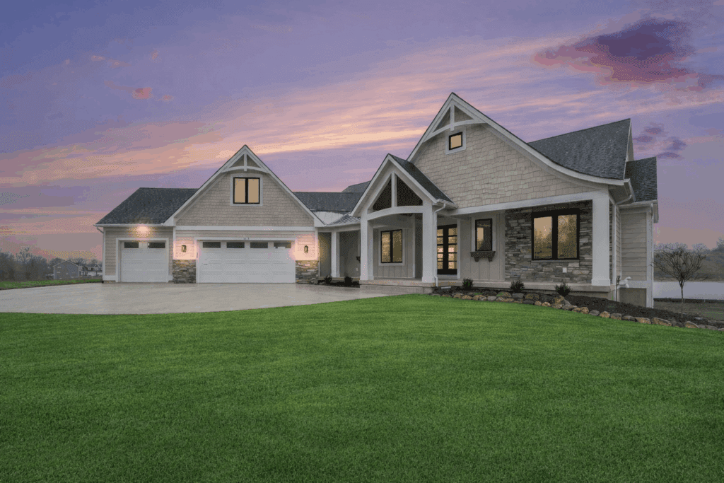 Front exterior of modern transitional craftsman style luxury custom home at dusk on Jamestown Shores Lake in Hudsonville, Michigan.